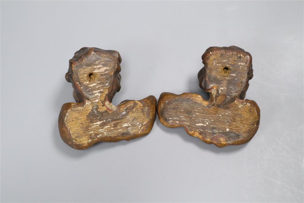 A pair of late 18th/early 19th century carved painted cherub heads, height 9cm.